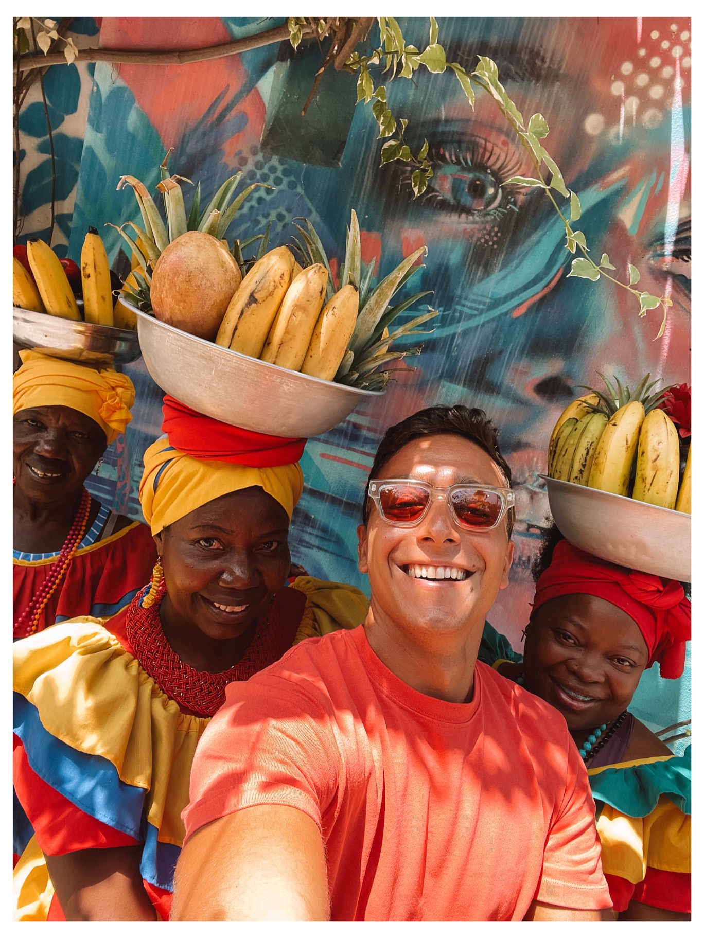 msarchia sharing a joyful moment with local fruit vendors in a colourful street setting