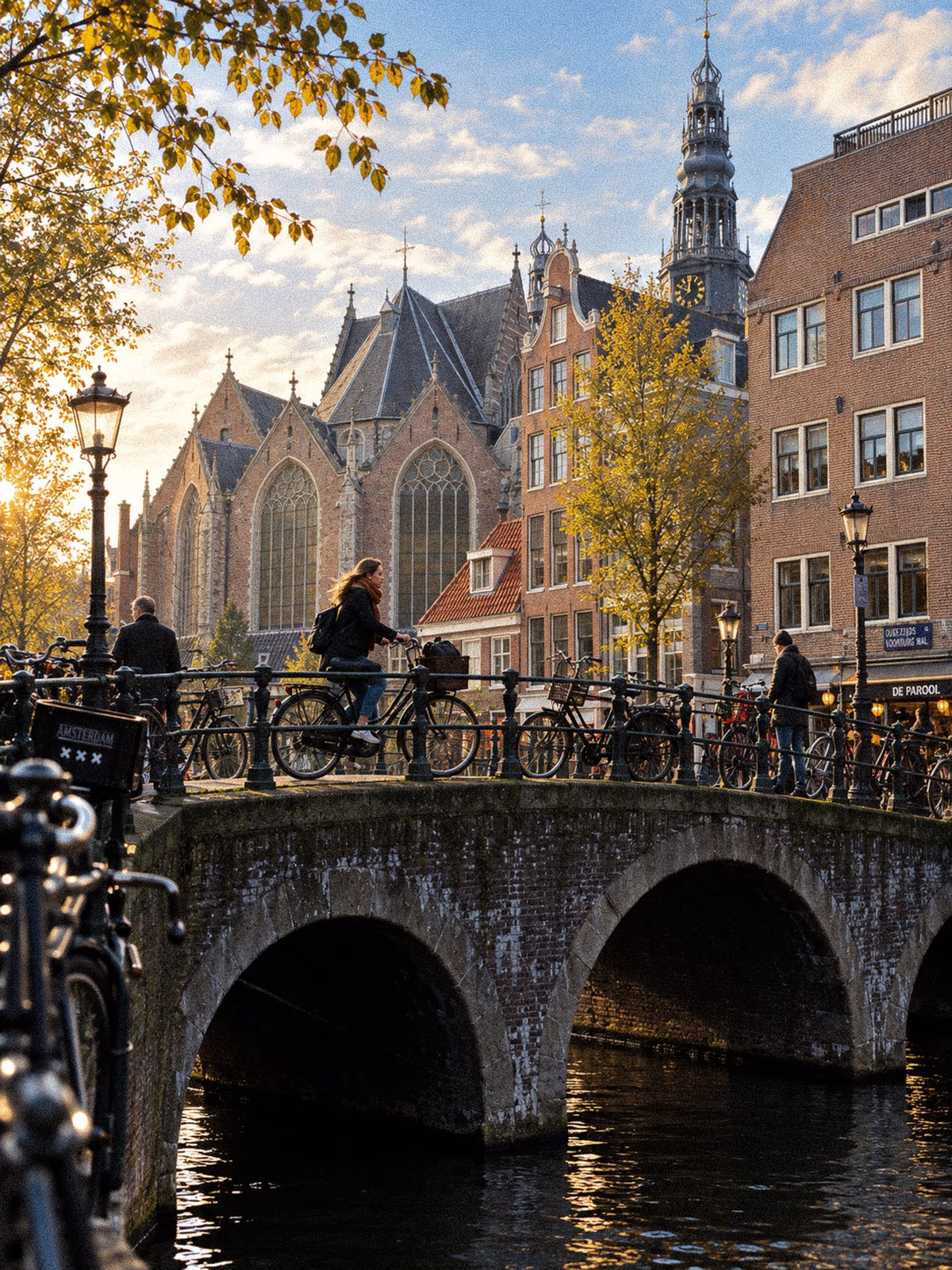 A bridge and historic Amsterdam street leading toward the Oude Kerk