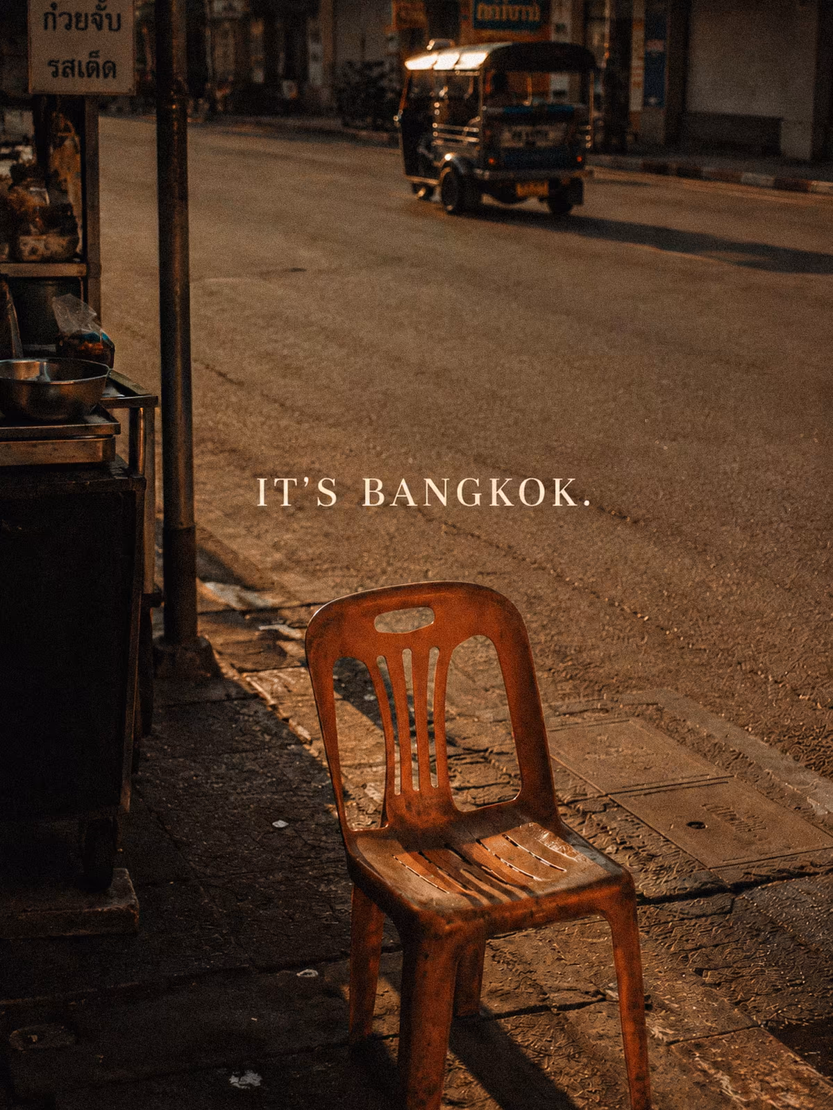A weathered red chair on a Bangkok street