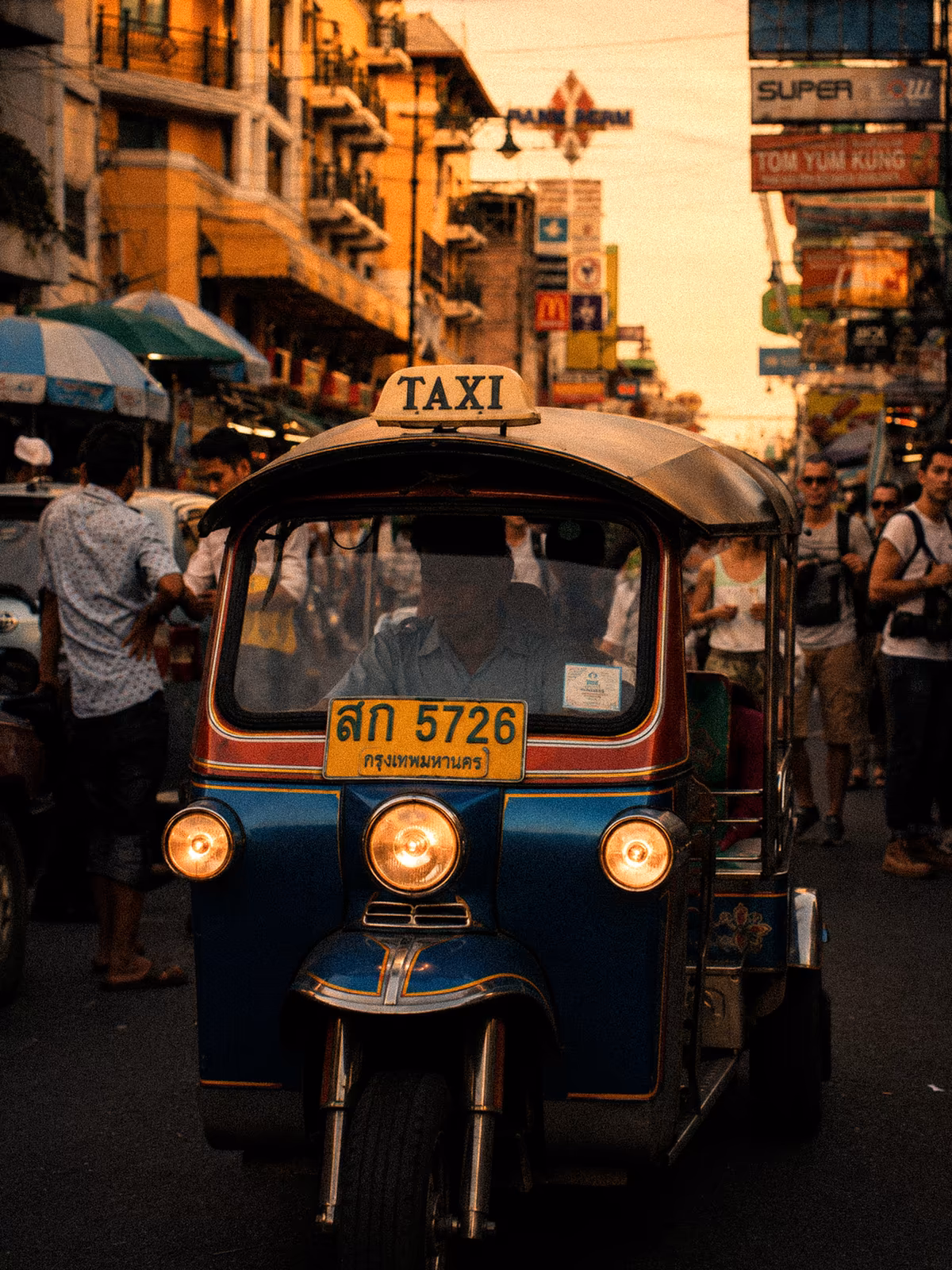 Blue tuk-tuk facing the camera in a Bangkok street