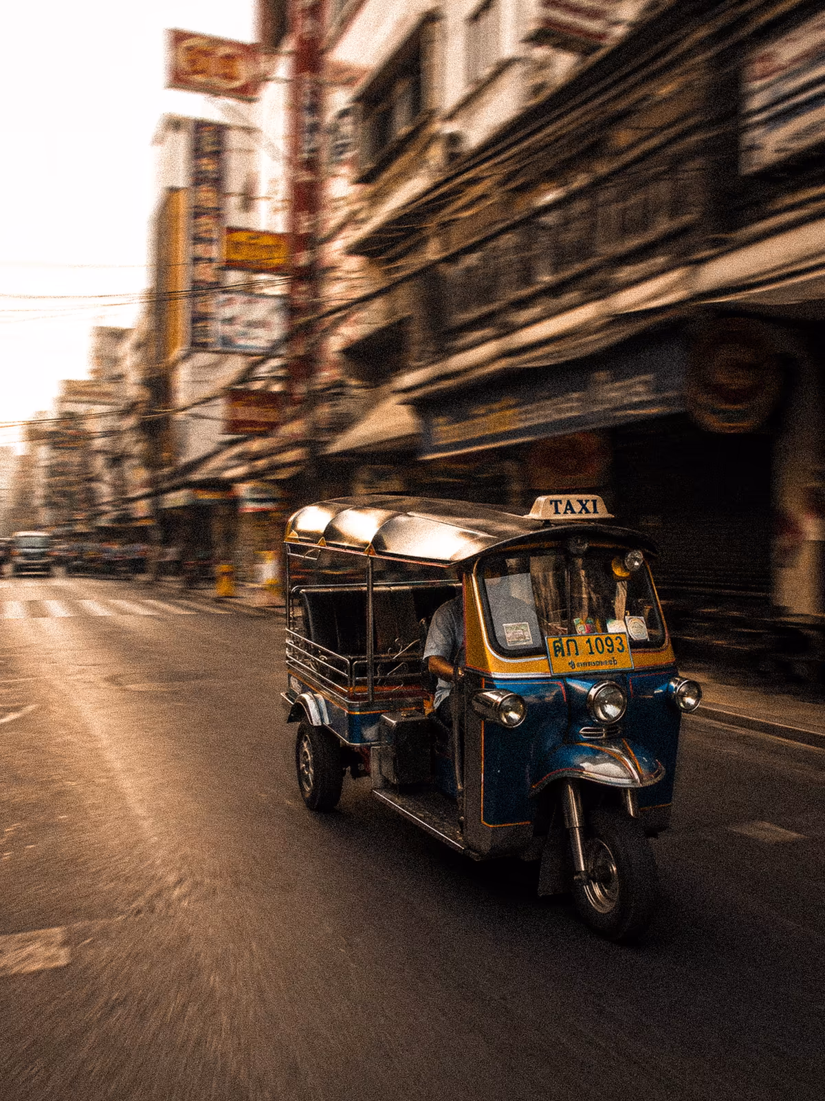 Tuk-tuk moving through a Bangkok street