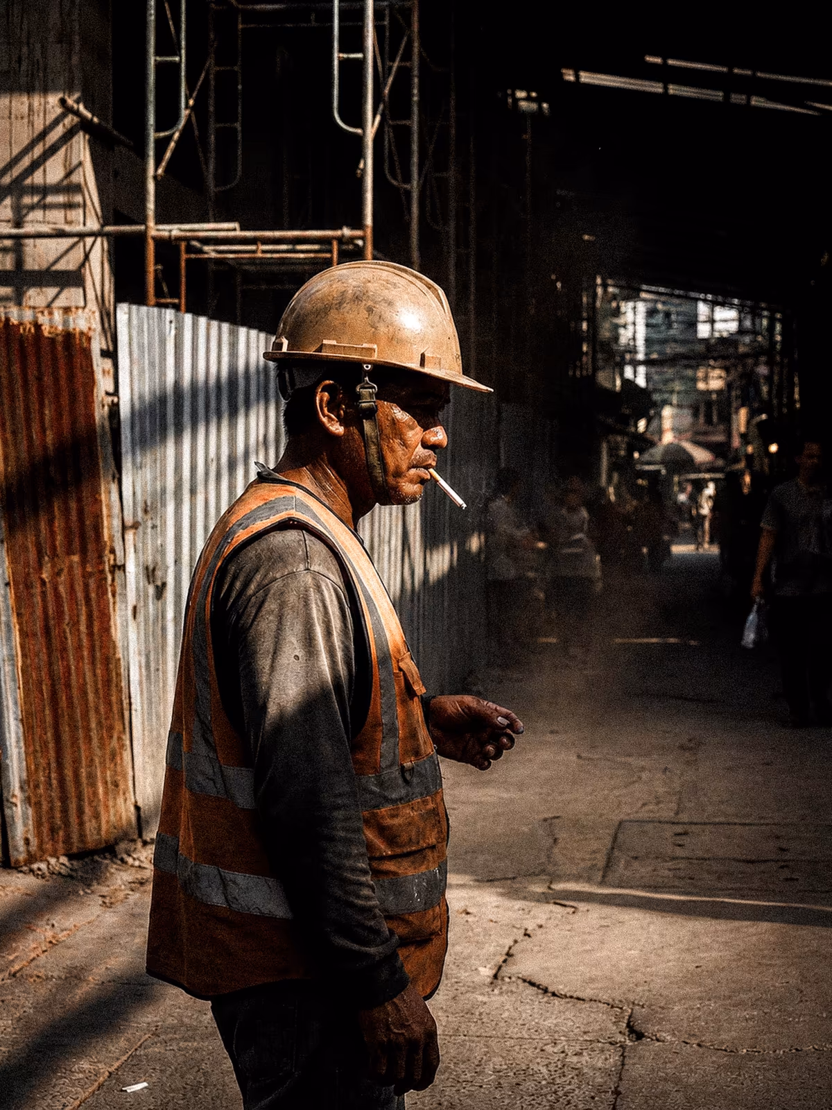 Bangkok worker outlined by a shaft of side light