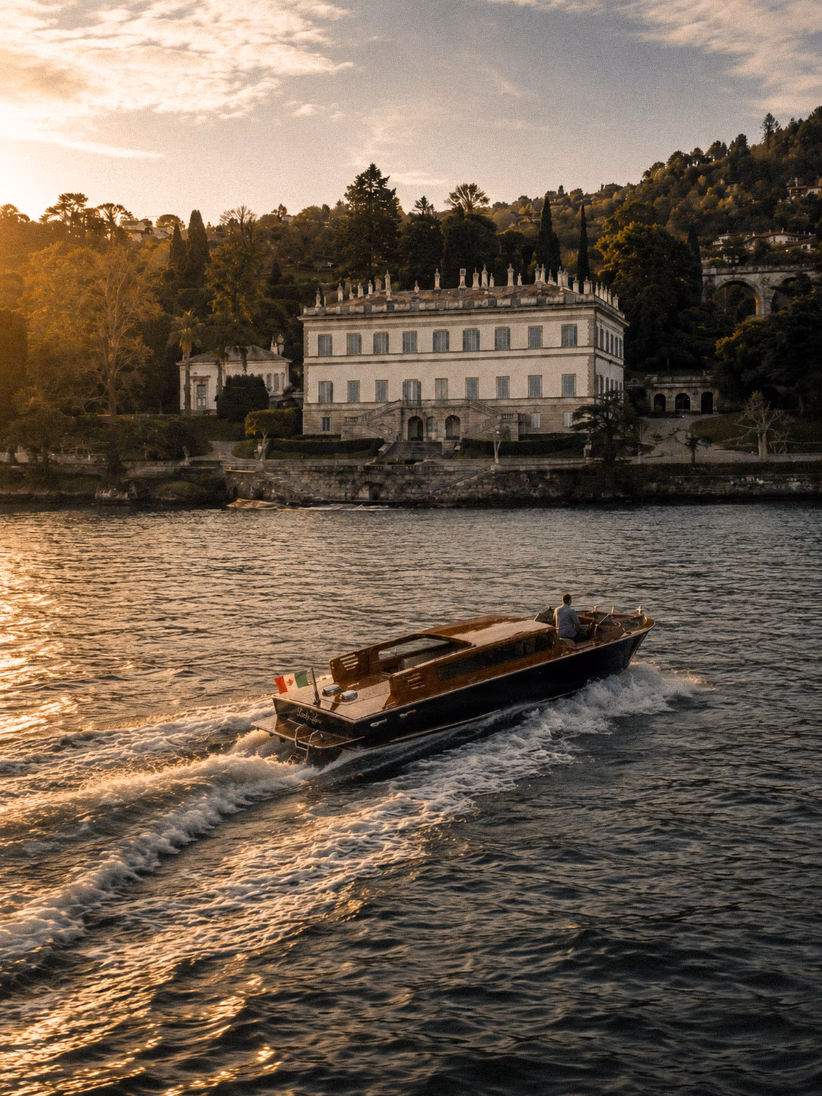 A ferry crossing in front of a historic Lake Como villa