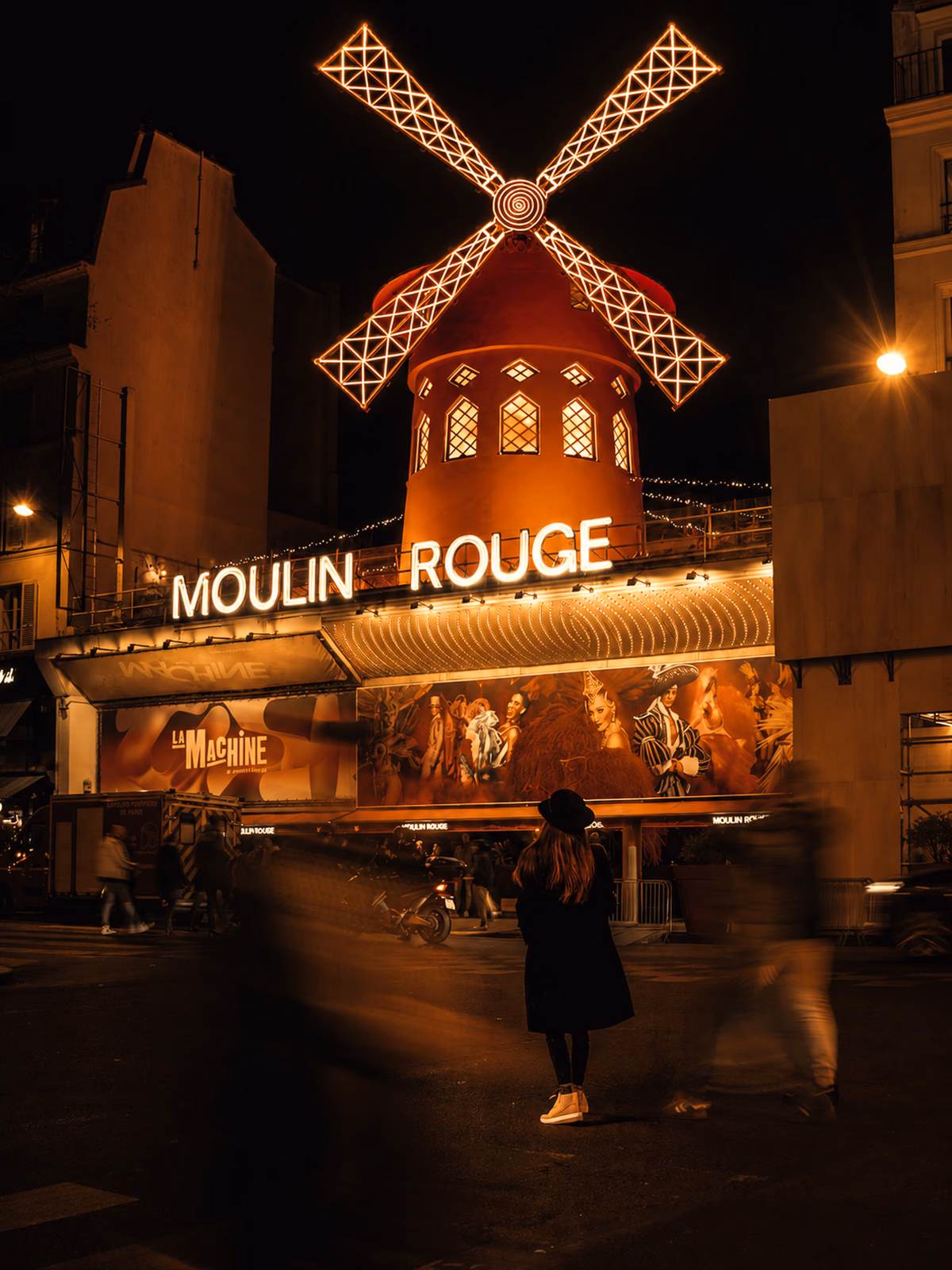 Moulin Rouge windmill illuminated against a dark Paris night