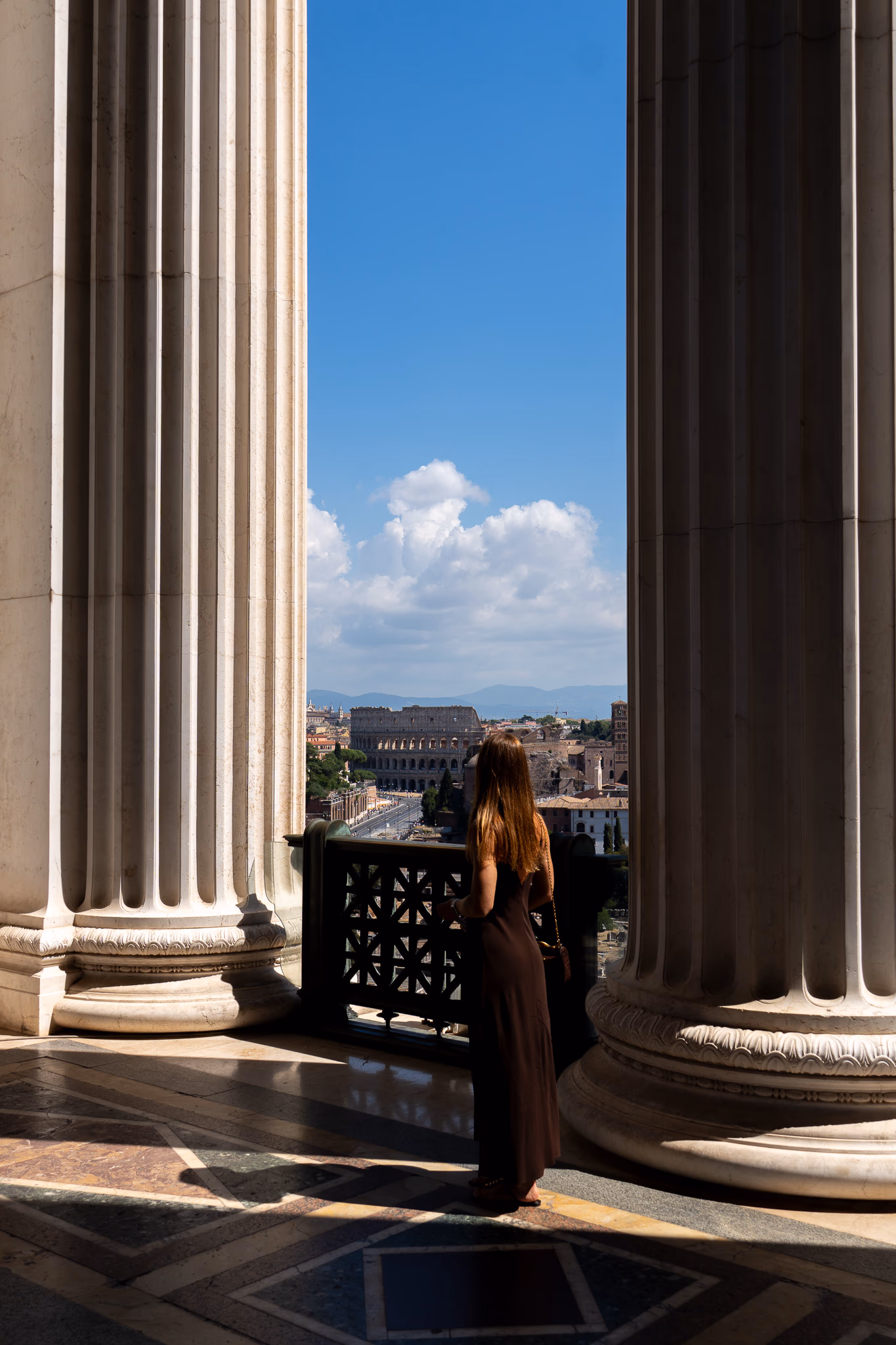 The Colosseum framed between the monumental columns of the Altare della Patria