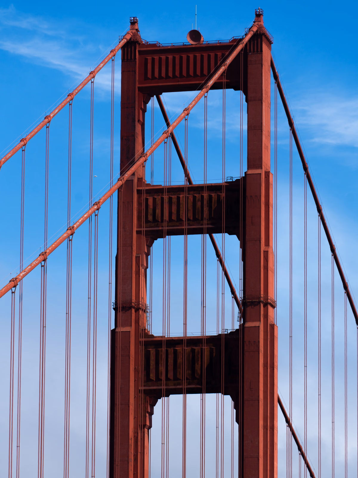 A close view of the Golden Gate Bridge structure against blue sky