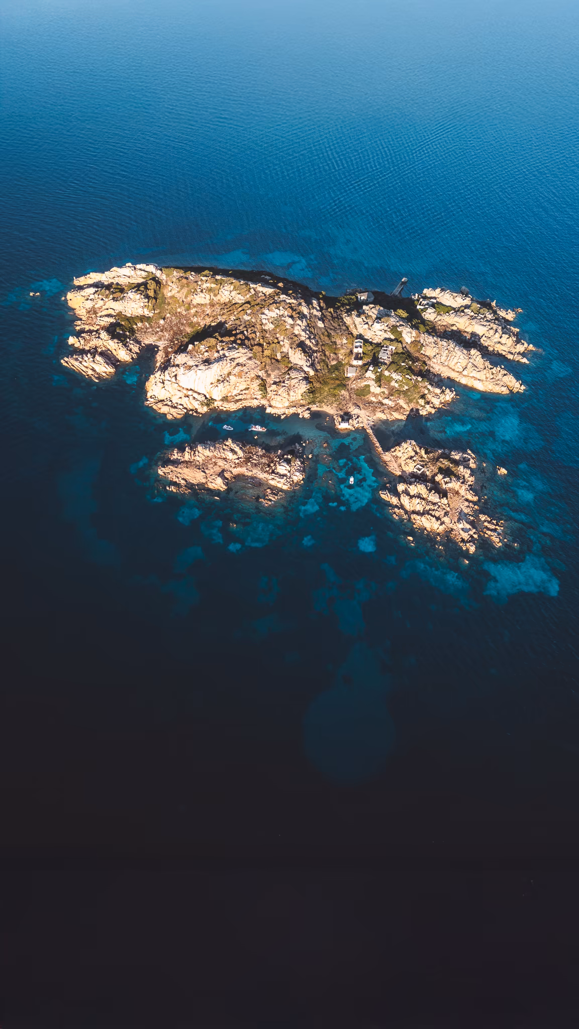 A small granite island surrounded by deep blue Sardinian water