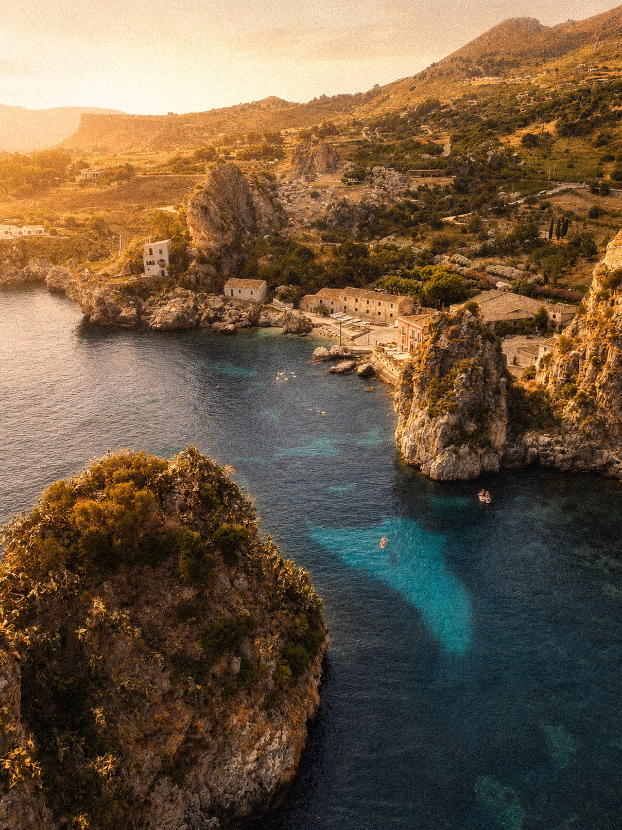 The historic Tonnara di Scopello and its faraglioni seen from above